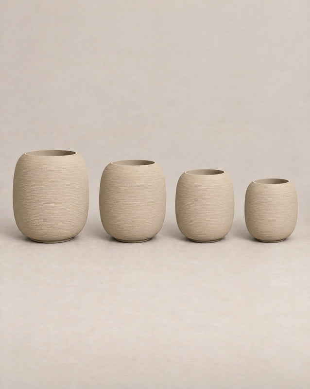 Durum Tall putty stone outdoor planter with a rounded barrel shape and footed base