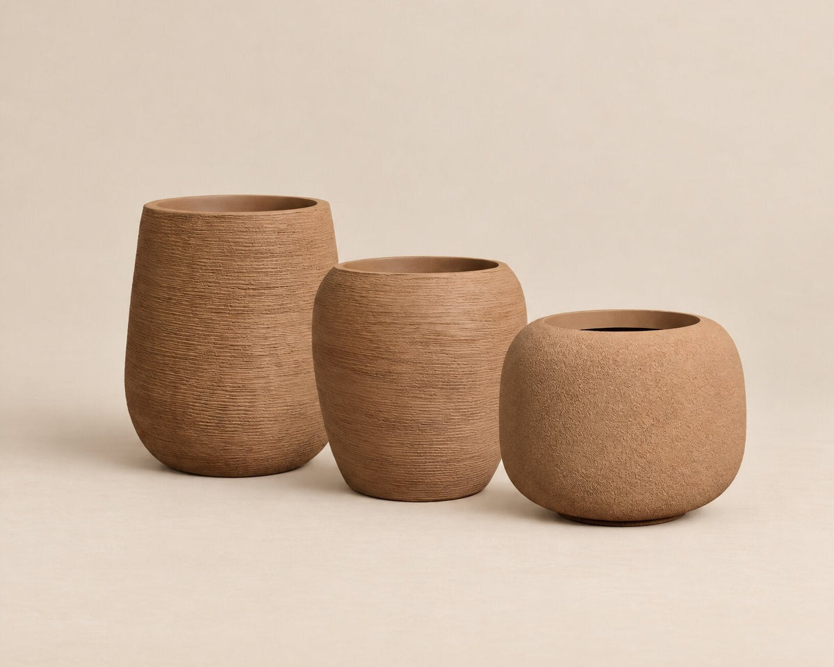 Three  textured lightweight planters in varying heights, made of a warm sandy brown material, arranged on a matching beige background.