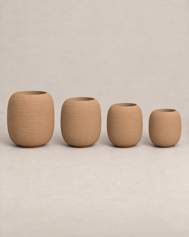 Durum Tall desert stone outdoor planter with a rounded barrel shape and footed base