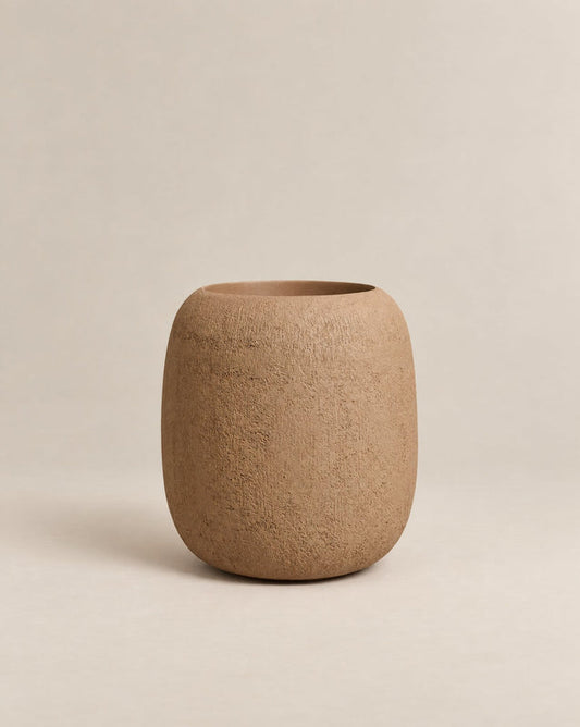 Durum Tall desert rough outdoor planter with a rounded barrel shape and footed base