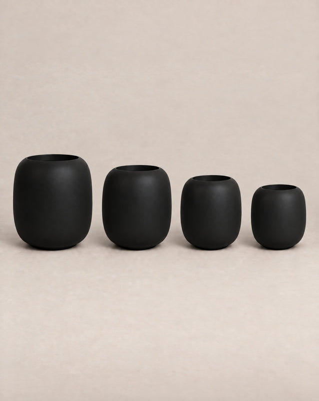 Durum Tall black outdoor planter with a rounded barrel shape and footed base
