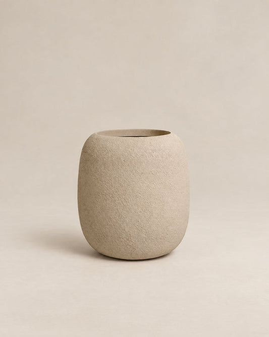 Durum Tall putty rough outdoor planter with a rounded barrel shape and footed base
