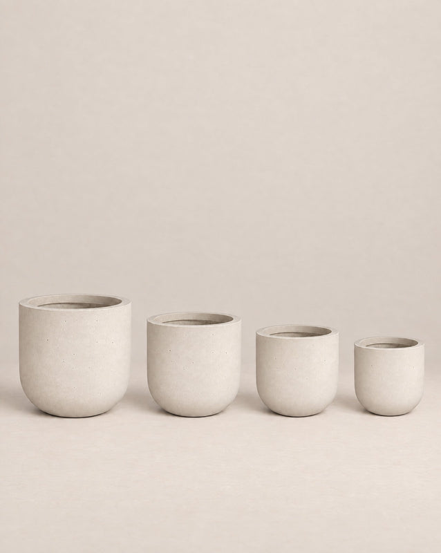 Tassina grey outdoor planter with cylindrical walls and a rounded base